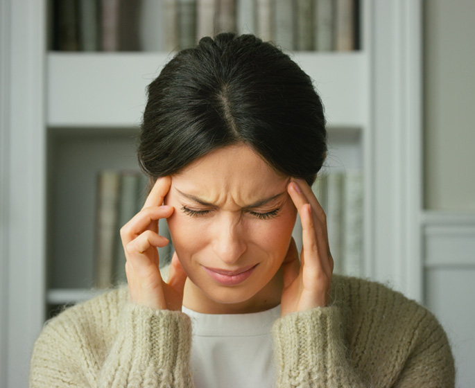 Slika mlade žene koja doživljava intenzivnu vrtoglavicu, hvatajući se rukama za glavu i sklapajući oči u znak nelagode. Izraz lica odražava akutni osjećaj dezorijentacije i poteškoće u održavanju ravnoteže, što su tipični simptomi vrtoglavice. Slika efektivno prenosi tjelesnu i emocionalnu reakciju na ovaj čest zdravstveni problem, naglašavajući subjektivno iskustvo osobe pogođene ovim stanjem.